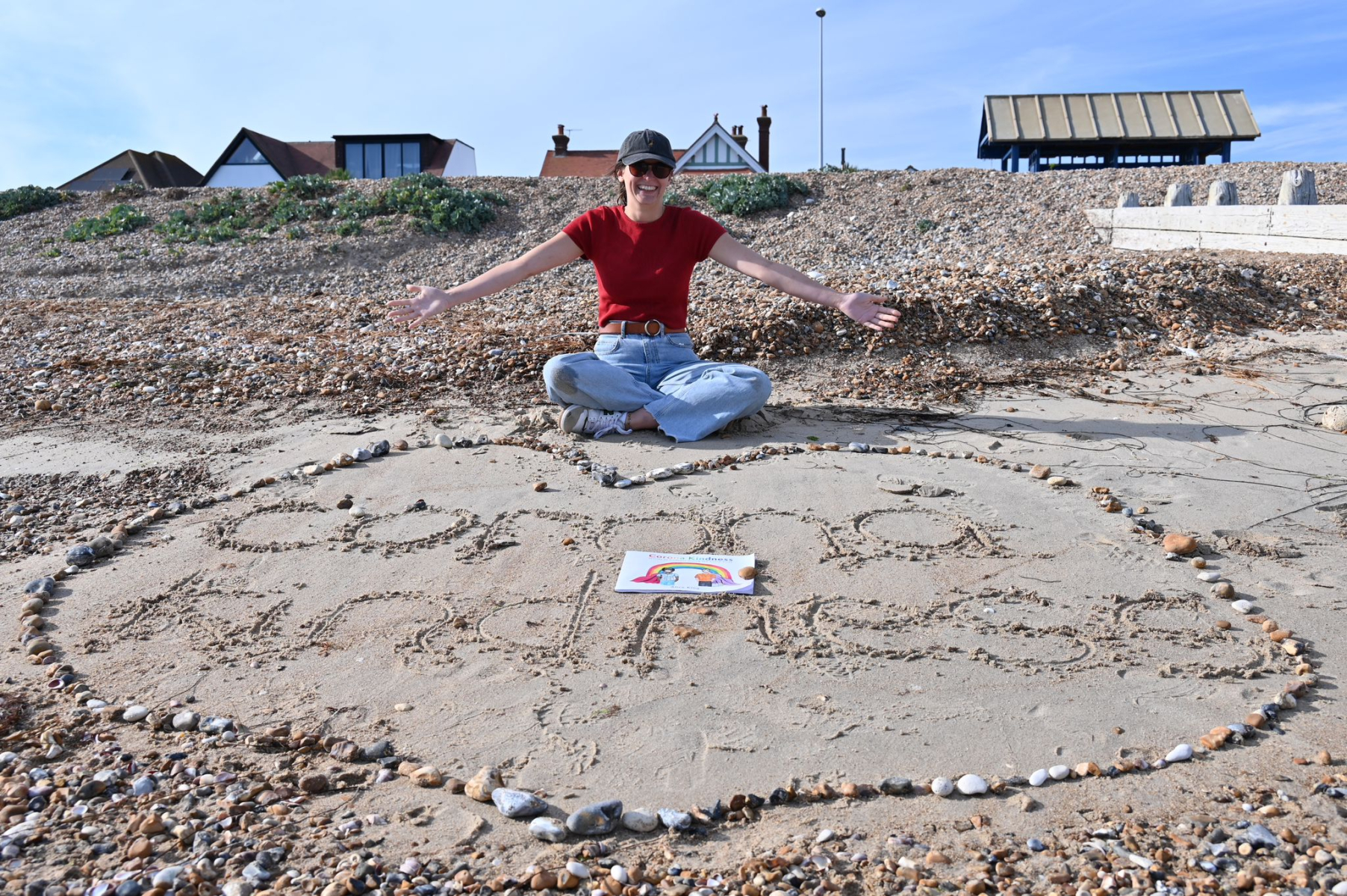 Corona Kindness written in sand on a beach