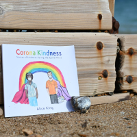 Corona Kindness book next to a beach groyne